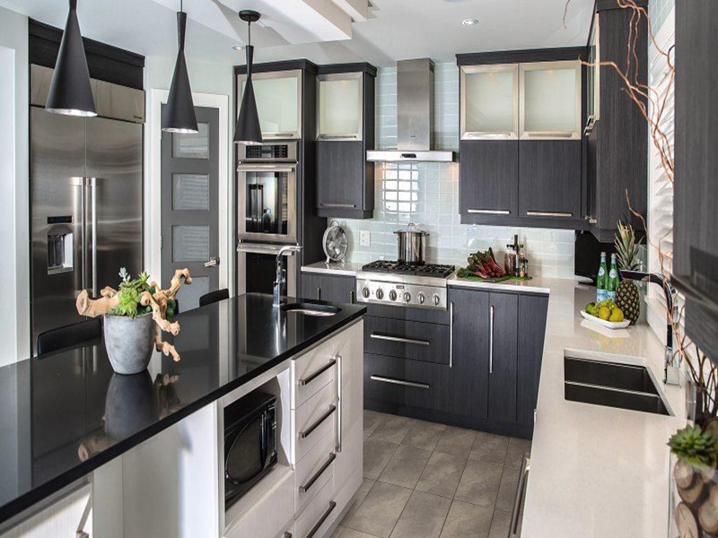 Hochwertige Küchenschränke aus weiß lackiertem Massivholz mit schwarzen Arbeitsplatten